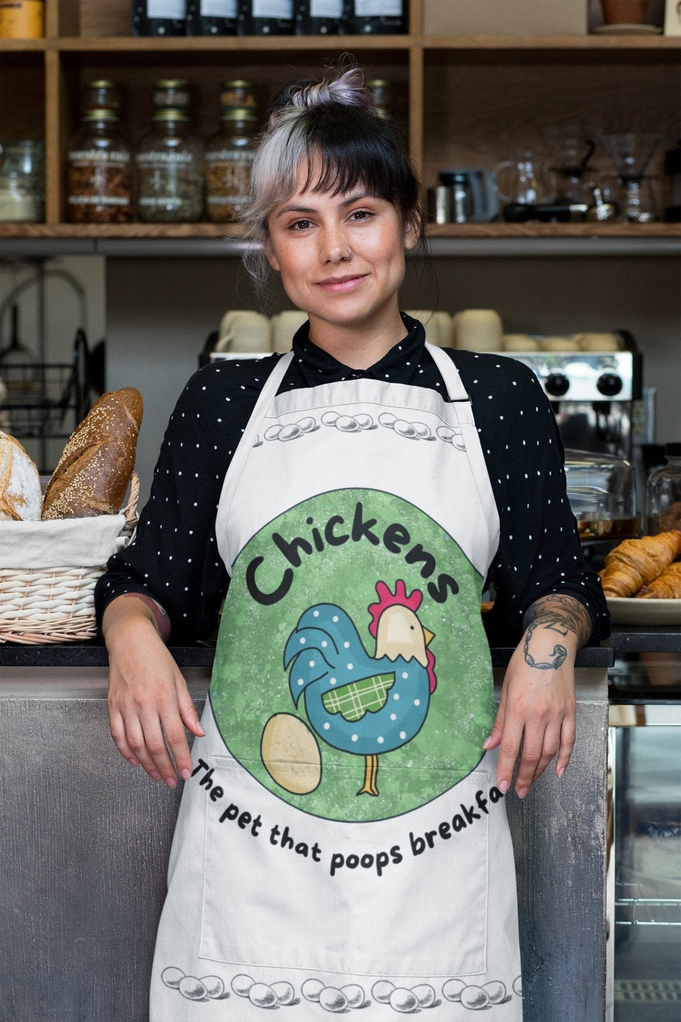 lady wearing an apron that says "chickens the pet that poops breakfast"